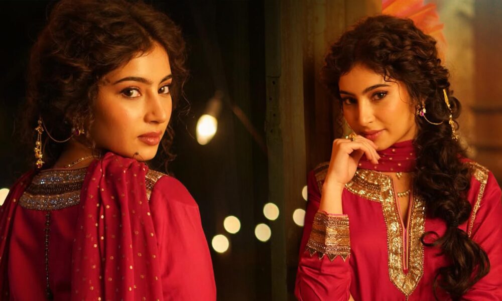 Sara Arjun wearing a rose pink embroidered kurta with matching dupatta and sharara, styled in a traditional indoor setting with warm lighting.